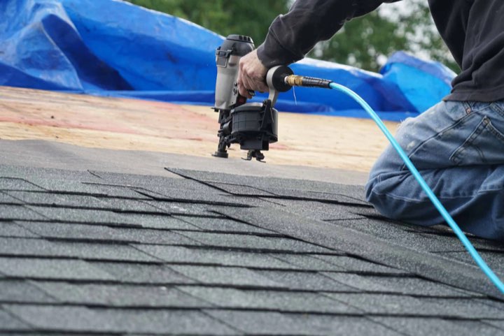 Dakdekker van Daktrots zet bitumen shingles vast met een tacker