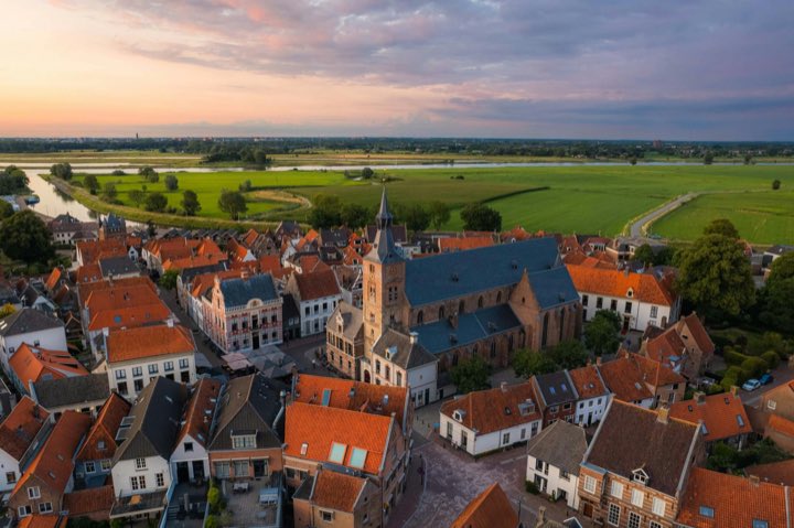 Pannendaken van een Hollands stadje bij zonsondergang