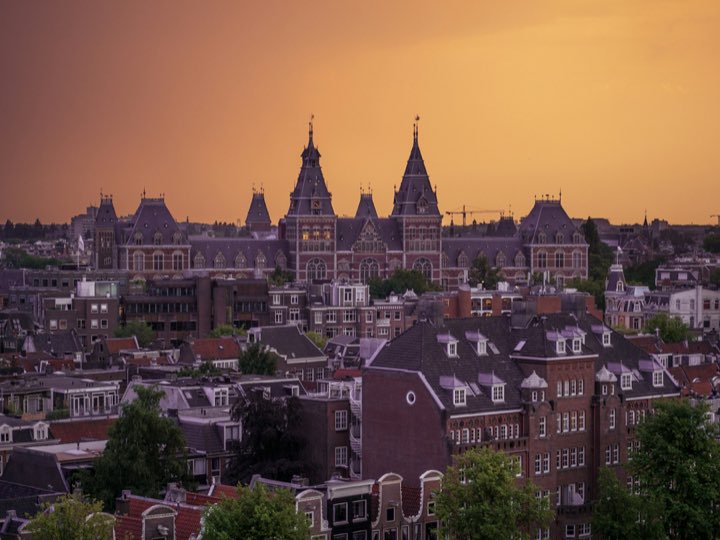 Amsterdamse daken bij zonsondergang met het Rijksmuseum